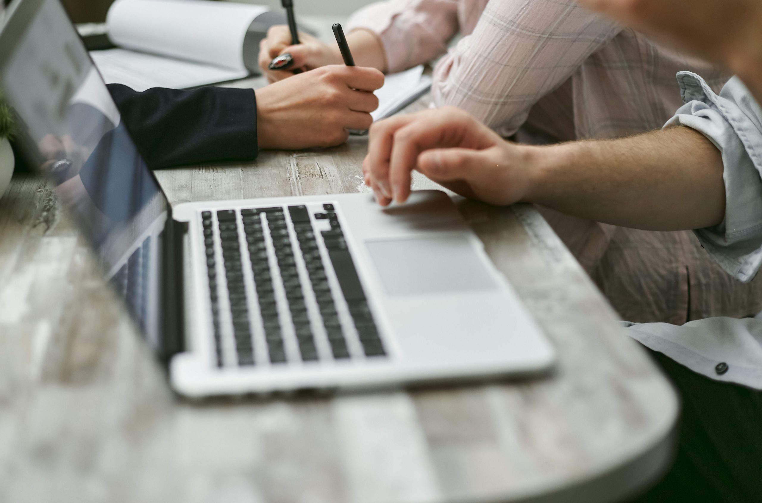Employees using a laptop and reviewing business documents.