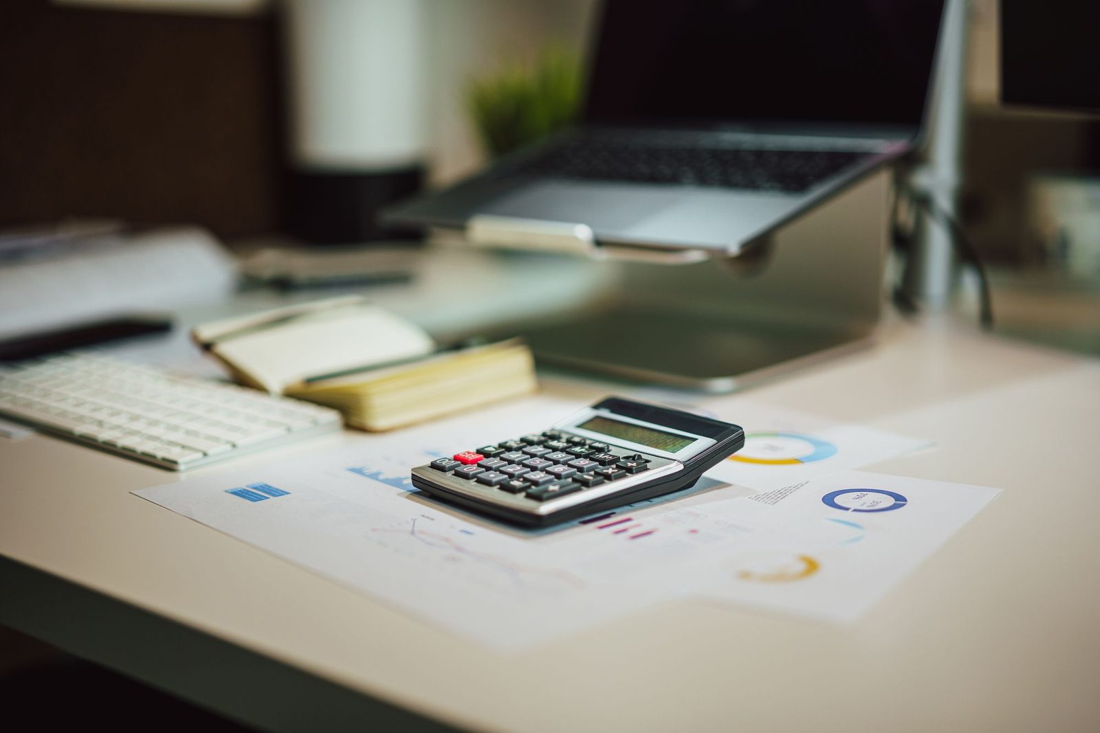 Laptop, calculator and documents used for business budgeting.